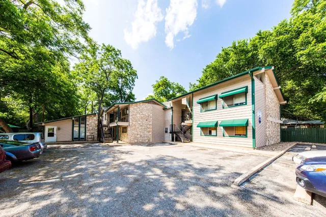 a view of a house with a big yard and large tree