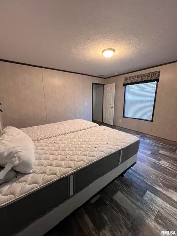 a bed sitting in a bedroom next to a lamp