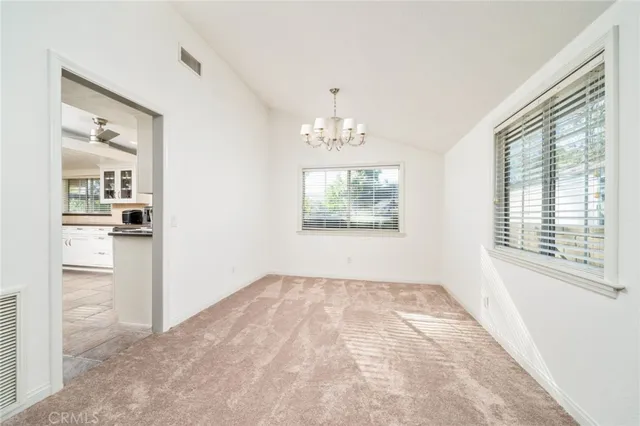 an empty room with chandelier and windows