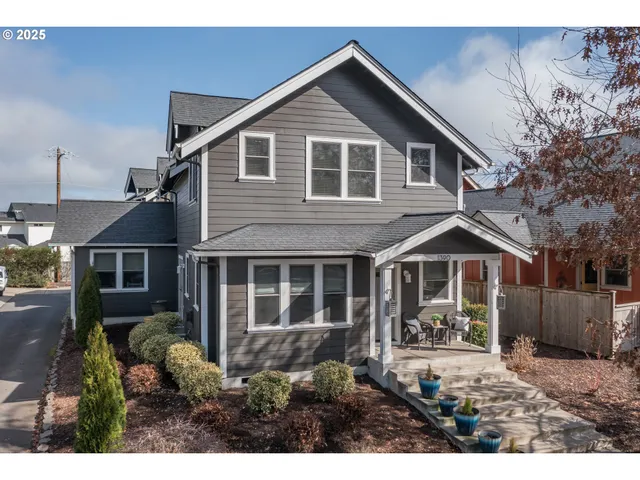 a front view of a house with a yard and potted plants