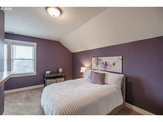 a bedroom with a bed and a painting on the wall