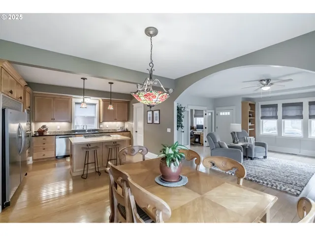 a view of a dining room and livingroom with furniture wooden floor a chandelier