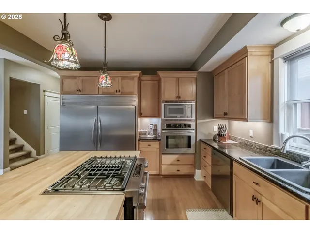 a kitchen with granite countertop a sink cabinets and stainless steel appliances