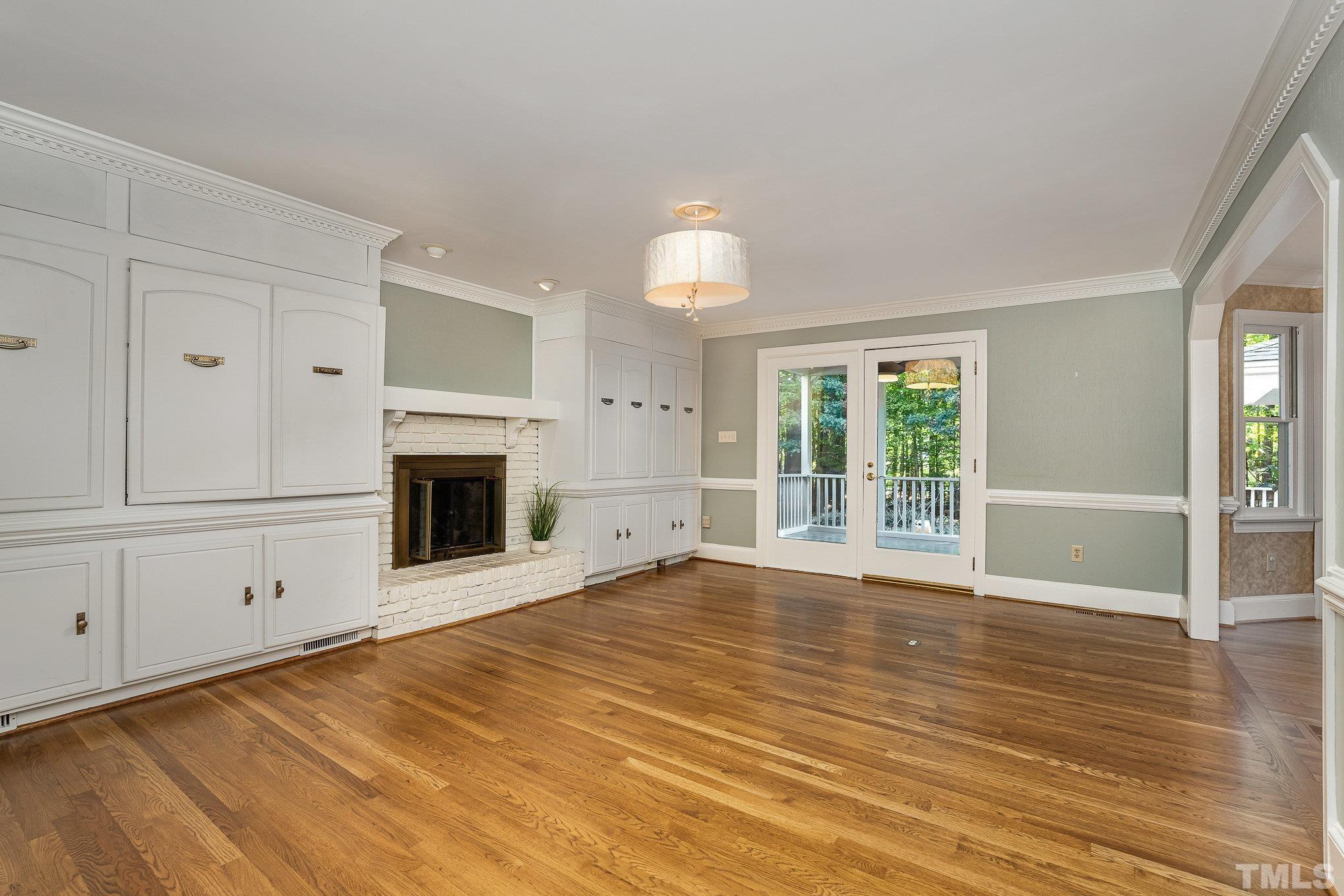 12036 Warwickshire Way Raleigh, NC 27613 - Photo 13 of 40 a view of an empty room with wooden floor fireplace and a window