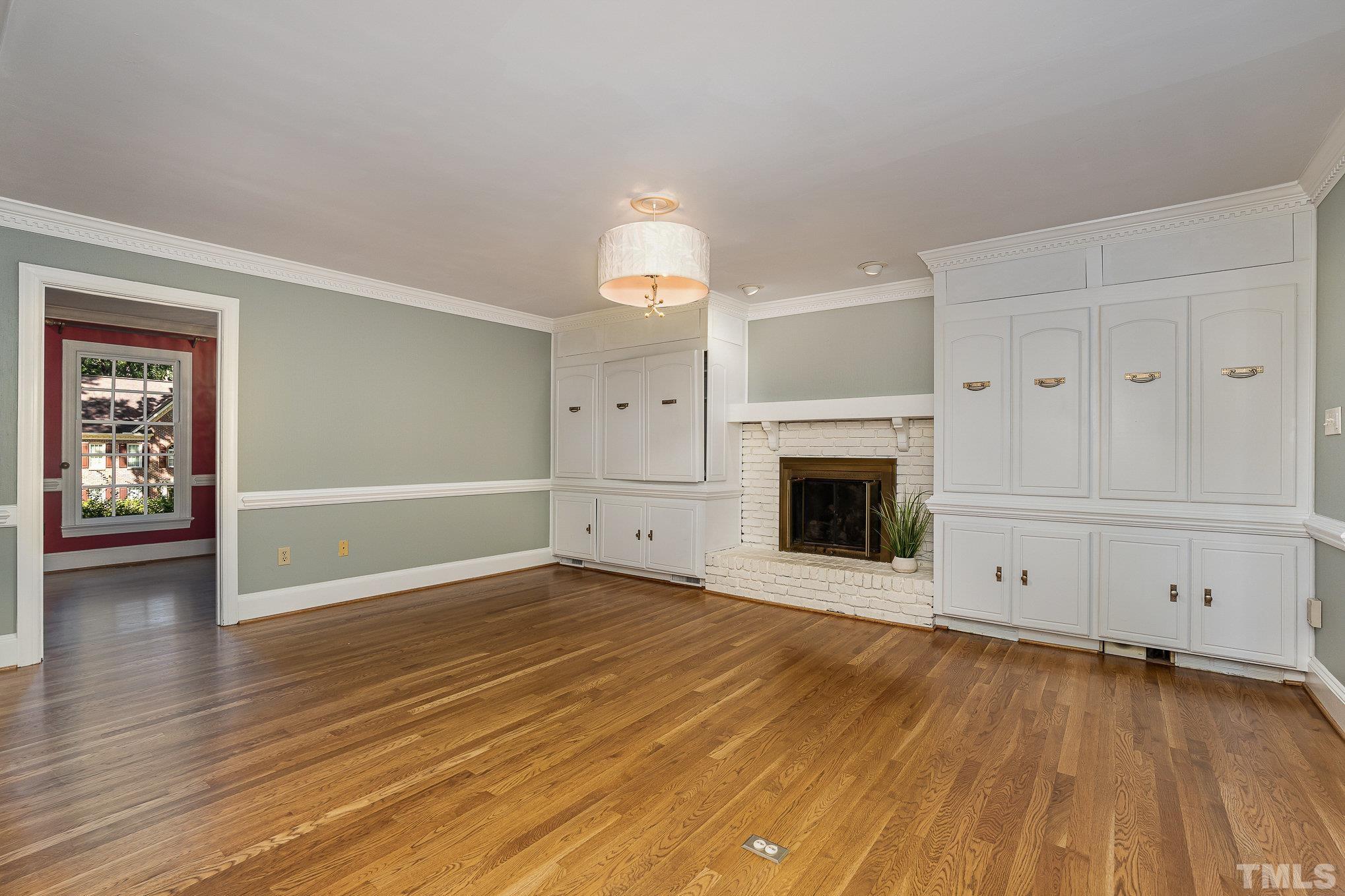 12036 Warwickshire Way Raleigh, NC 27613 - Photo 14 of 40 an empty room with wooden floor fireplace and windows
