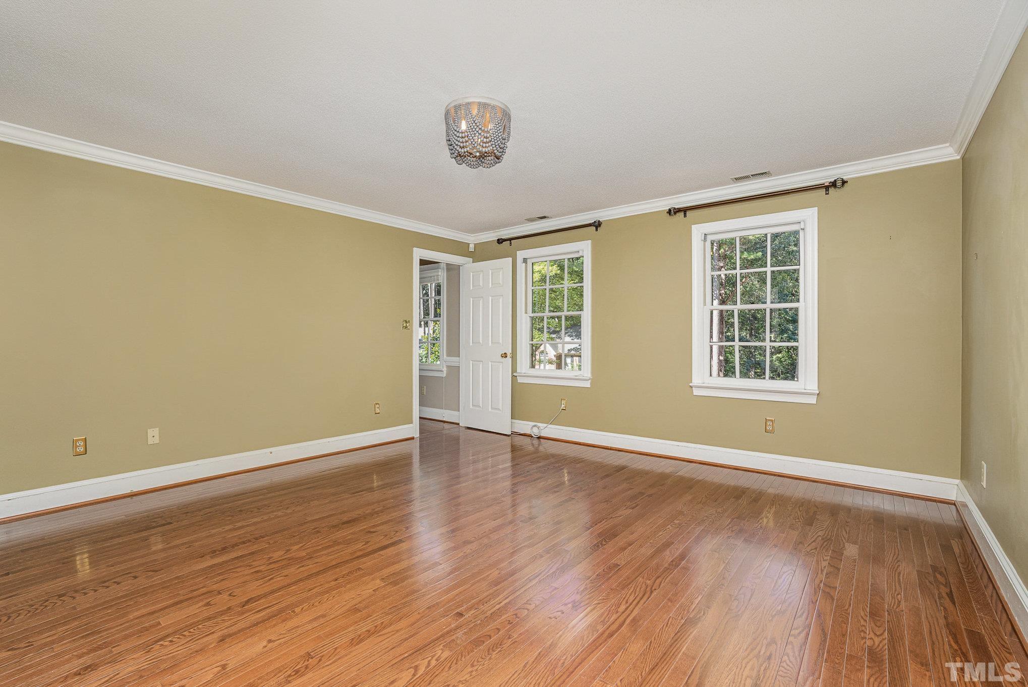 12036 Warwickshire Way Raleigh, NC 27613 - Photo 16 of 40 a view of an empty room with wooden floor and a window