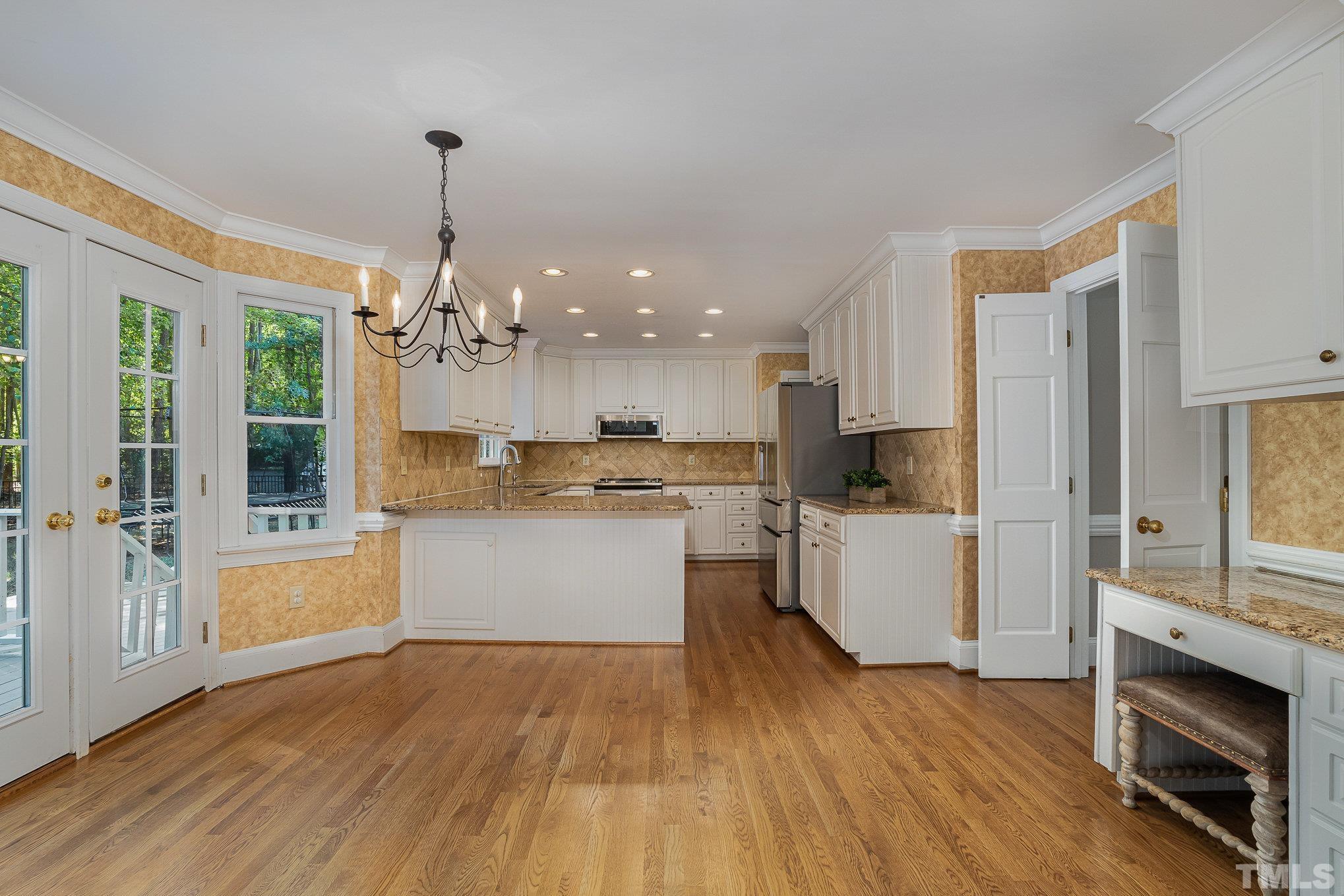 12036 Warwickshire Way Raleigh, NC 27613 - Photo 5 of 40 a large kitchen with cabinets wooden floor and stainless steel appliances