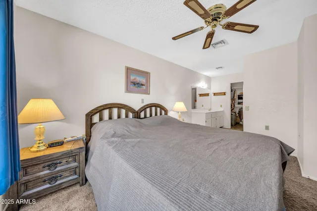 a spacious bedroom with a bed and a chandelier