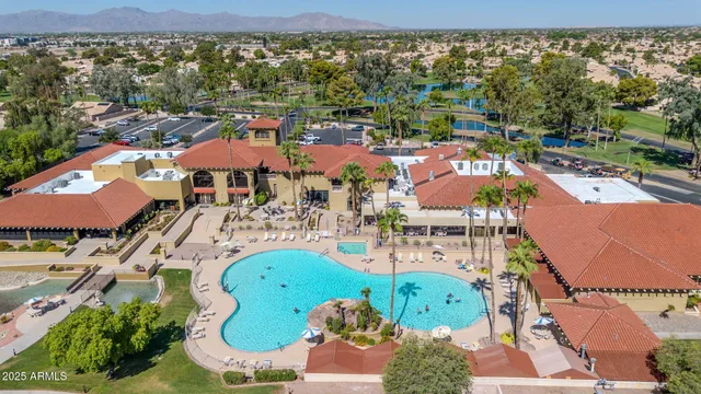 an aerial view of a houses with a swimming pool outdoor seating and yard