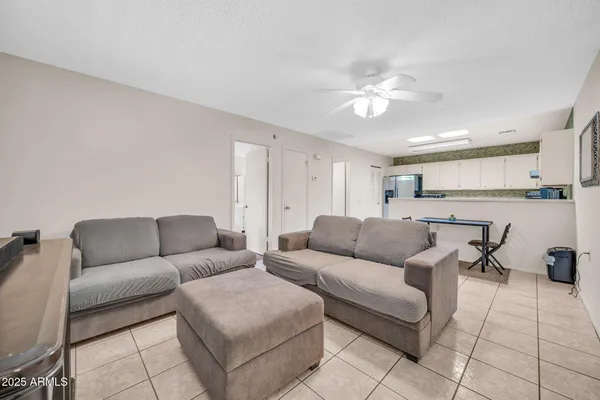 a living room with furniture and a view of kitchen