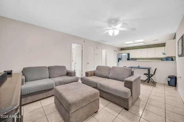 a living room with furniture and a view of kitchen