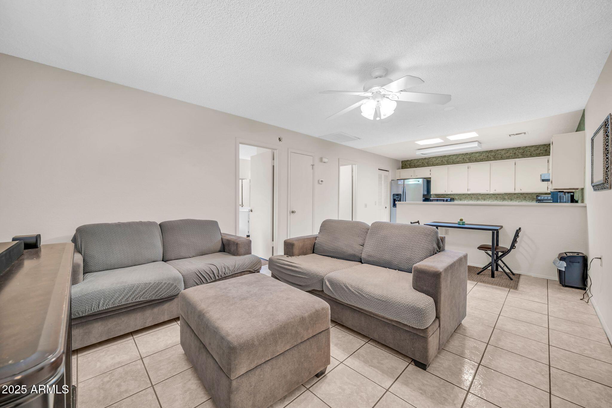 14300 West Bell Road, Unit 83 Surprise, AZ 85374 - Photo 4 of 22 a living room with furniture and a view of kitchen
