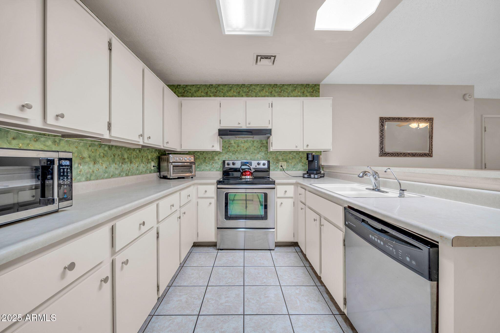 14300 West Bell Road, Unit 83 Surprise, AZ 85374 - Photo 6 of 22 a kitchen with granite countertop a sink and cabinets
