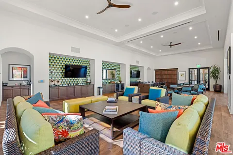 a living room with furniture kitchen view and a flat screen tv