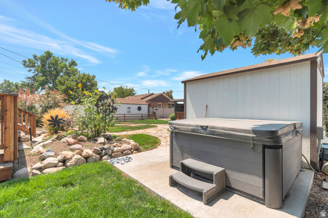 7391 Elm Street Midvale, UT 84047 - Photo 36 of 38 Outdoor spa with integrated steps, adjacent storage shed, and surrounding concrete patio