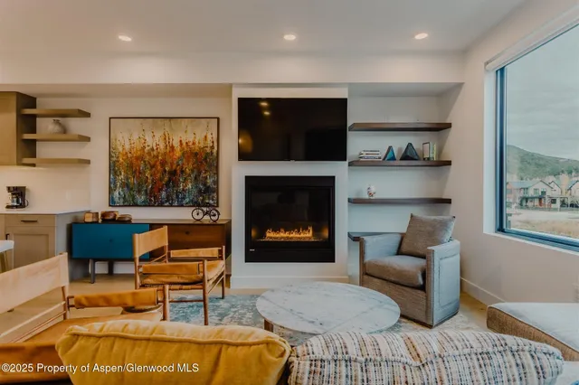 a living room with furniture and a painting on the wall