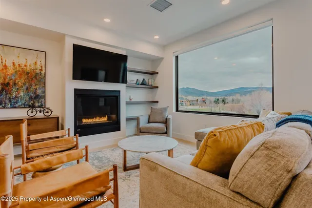 a living room with furniture a flat screen tv and a fireplace