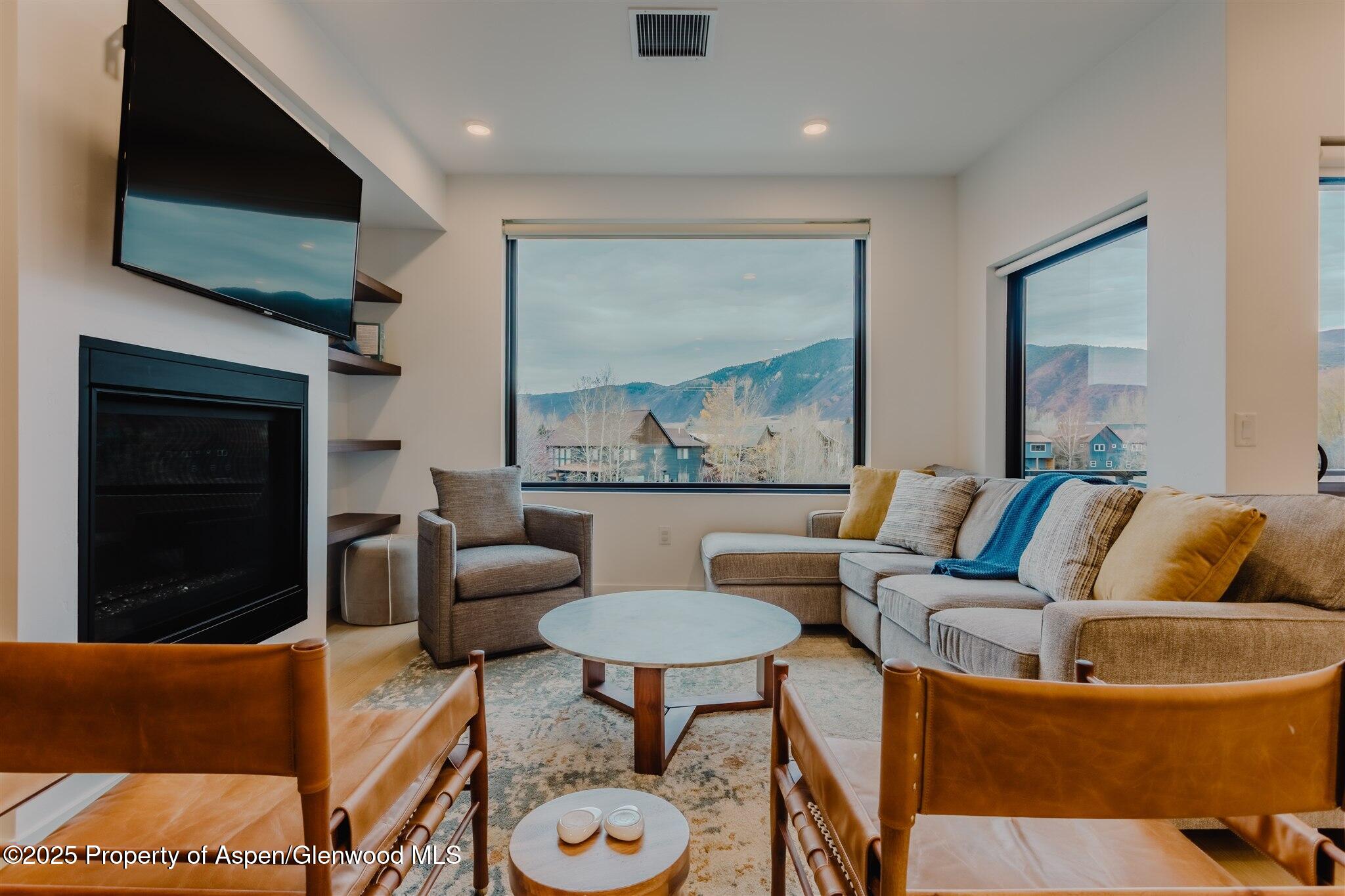 220 Lewis Lane Basalt, CO 81621 - Photo 20 of 62 a living room with furniture a flat screen tv and a fireplace