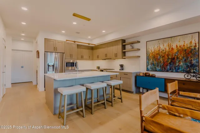 a kitchen with a table chairs refrigerator and cabinets