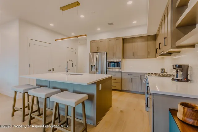a kitchen with kitchen island a table and chairs in it