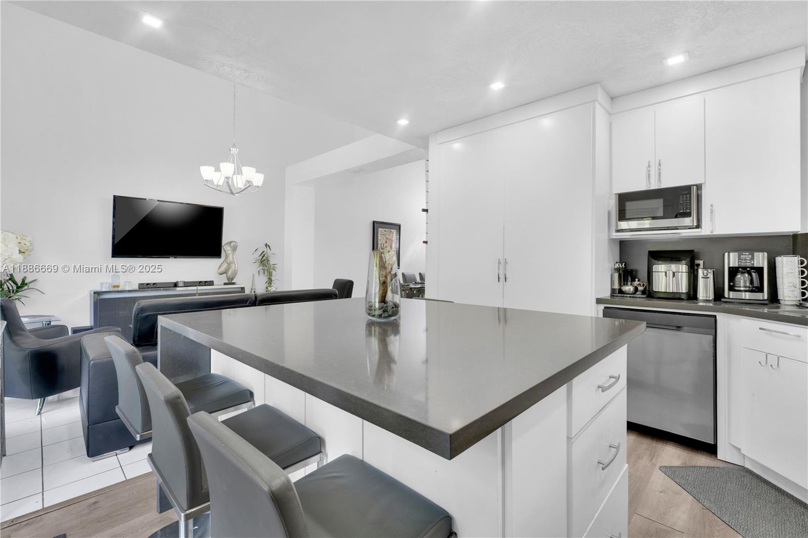 11126 Southwest 148th Place Miami, FL 33196 - Photo 11 of 33 a kitchen with stainless steel appliances a table chairs in it and a microwave