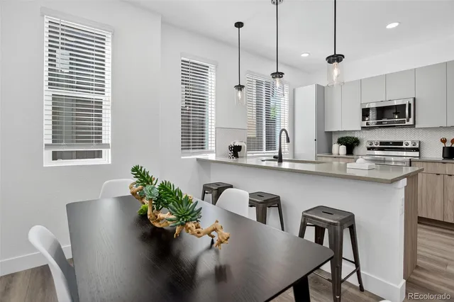 a kitchen with a sink stainless steel appliances and wooden floor
