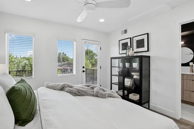 a bedroom with a bed a table and painting on the wall