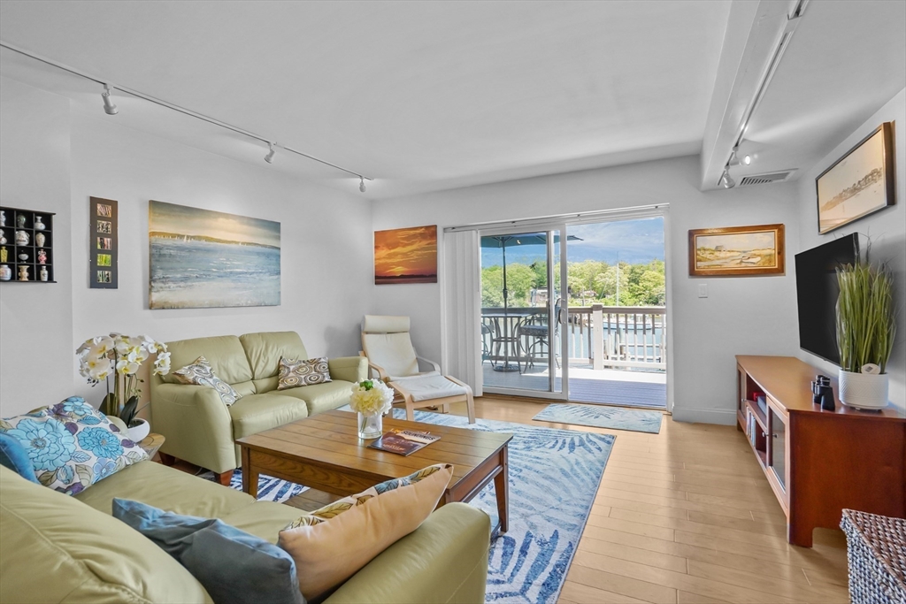 45 Main Street, Unit 112 Wareham, MA 02571 - Photo 2 of 30 a living room with furniture and a flat screen tv