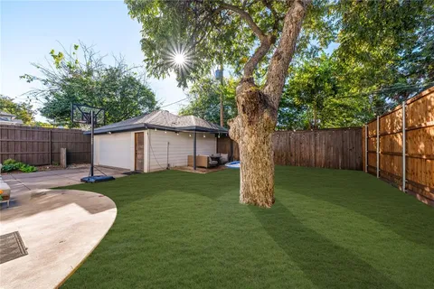 a view of a backyard with table and chairs and a large tree