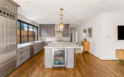 a open kitchen with stainless steel appliances granite countertop a stove and wooden floor