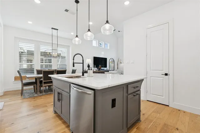 a kitchen with granite countertop a sink cabinets and wooden floor
