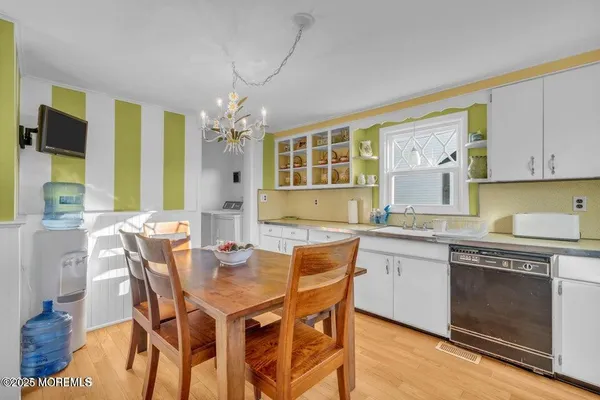 a kitchen with stainless steel appliances granite countertop a kitchen island hardwood floor sink stove and dining table