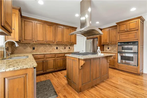 a kitchen with stainless steel appliances granite countertop a sink stove cabinets and wooden floor