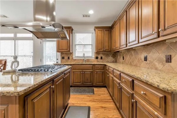 a kitchen with stainless steel appliances granite countertop a sink stove and cabinets