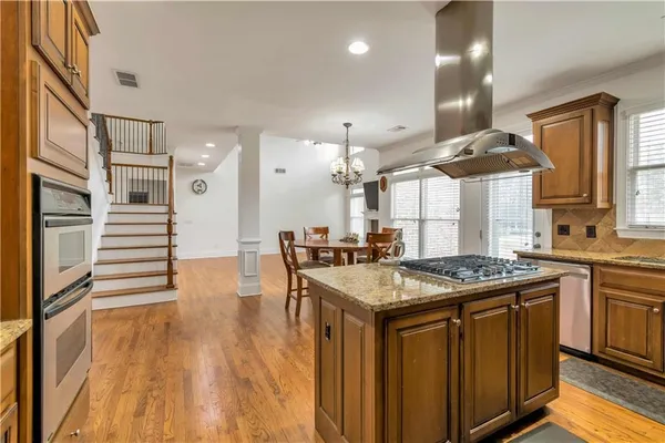 a kitchen with stainless steel appliances a stove a sink dishwasher and cabinets with wooden floor