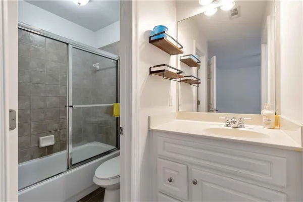a bathroom with a granite countertop sink a toilet and shower