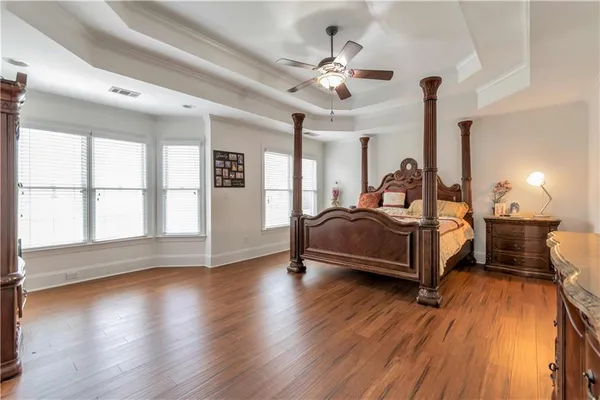 a spacious bedroom with a bed a chandelier and large window