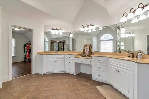 a spacious en suite bathroom with a double vanity sink and a mirror