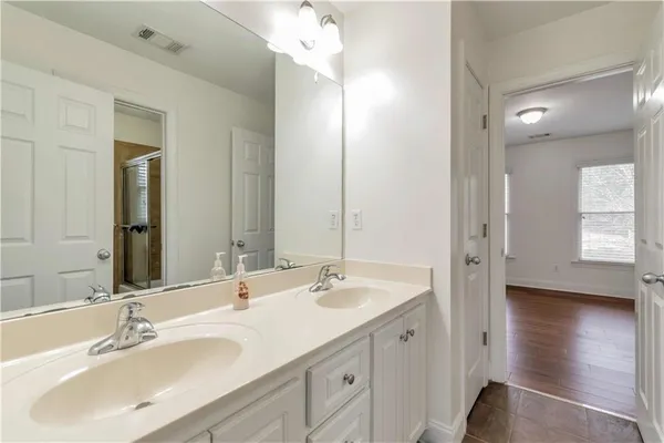 a bathroom with double vanity sinks and a mirror