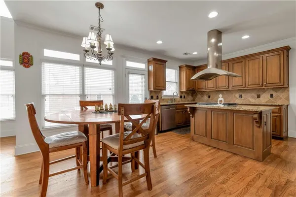a kitchen with a table chairs sink and cabinets