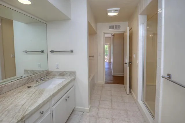 a bathroom with a granite countertop sink and a mirror