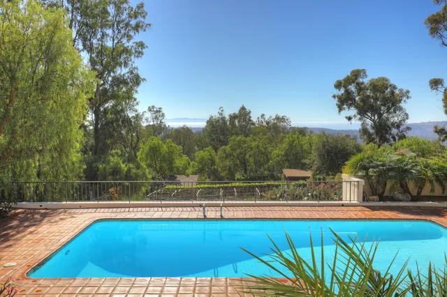 a view of a swimming pool with an outdoor seating and a yard