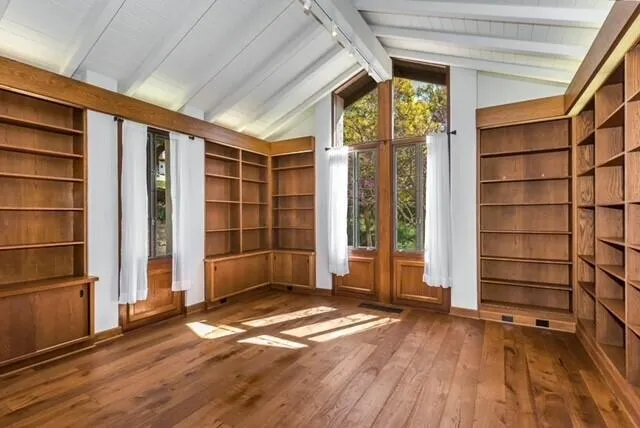 an empty room with wooden floor and door