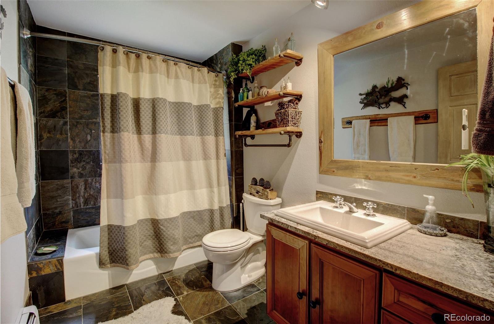 135 Nova Drive Pine, CO 80470 - Photo 21 of 38 a bathroom with a sink a toilet and shower curtain