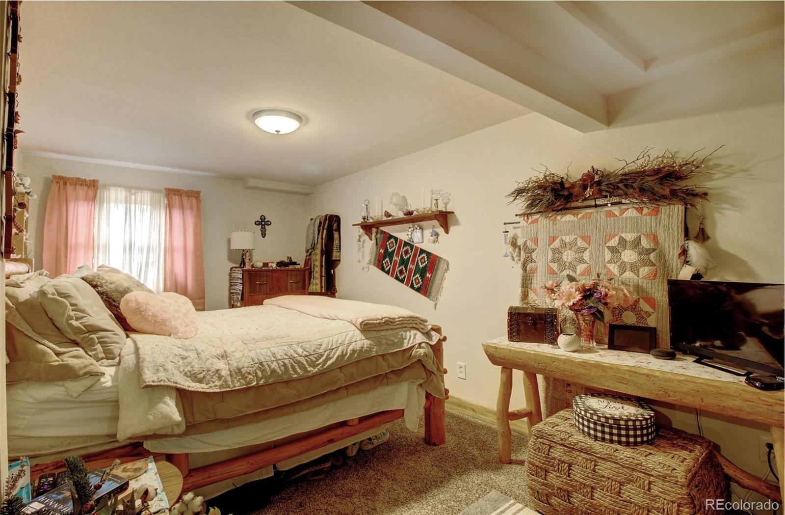 135 Nova Drive Pine, CO 80470 - Photo 26 of 38 a bedroom with a bed and large windows