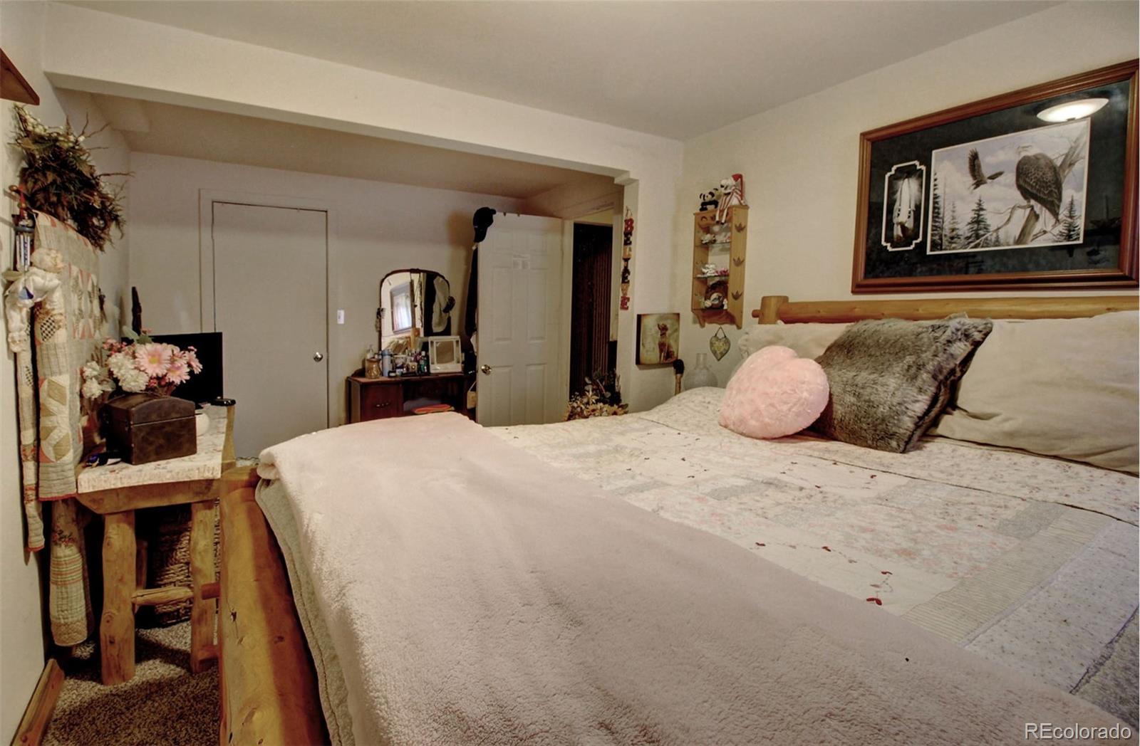 135 Nova Drive Pine, CO 80470 - Photo 27 of 38 a bedroom with a bed and a painting on the wall