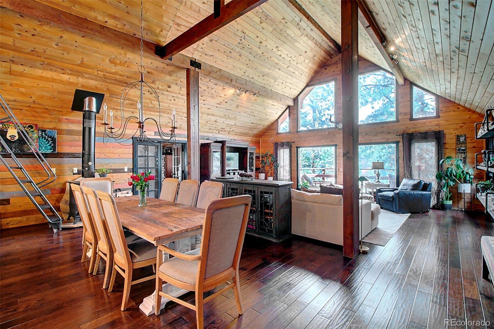 135 Nova Drive Pine, CO 80470 - Photo 3 of 38 a dining room with furniture large windows and wooden floor