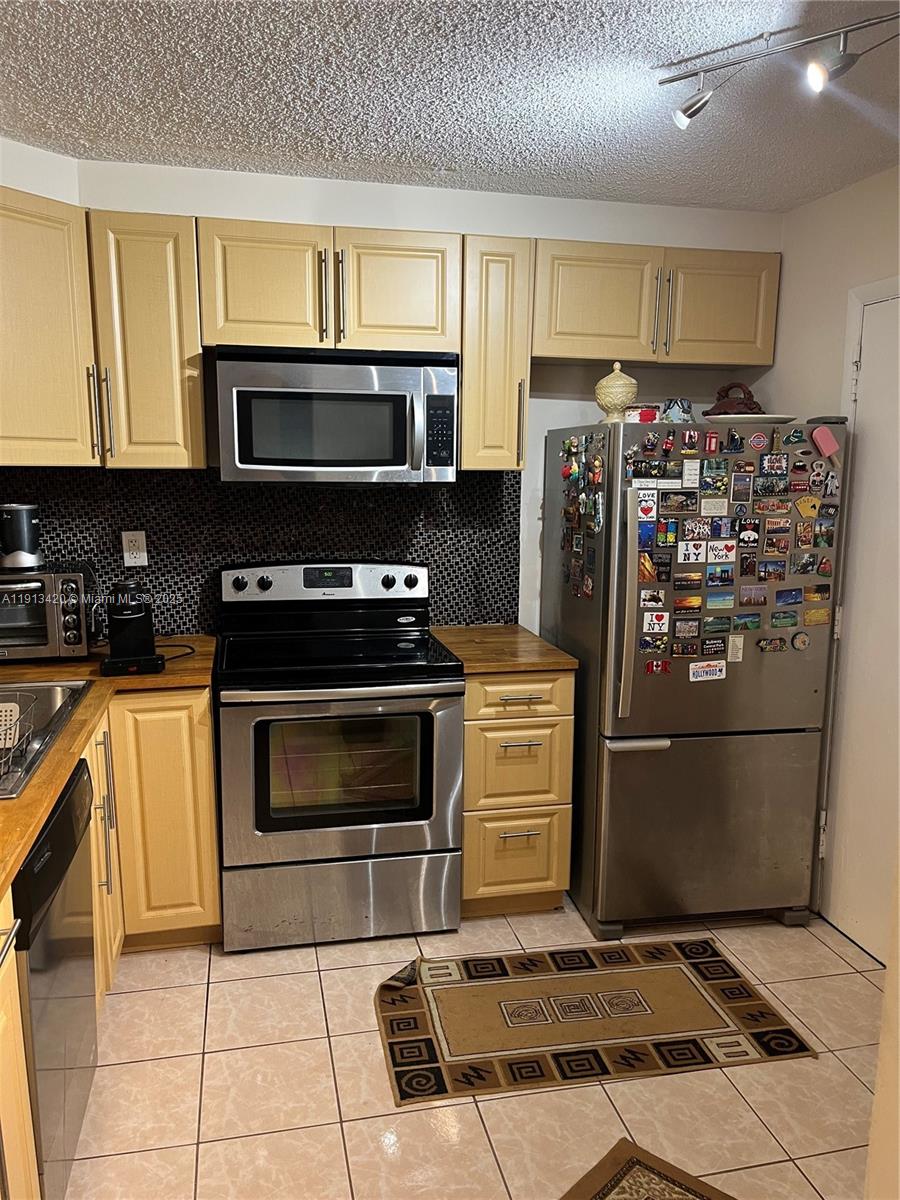 8233 Harding Avenue, Unit 305 Miami Beach, FL 33141 - Photo 18 of 46 a kitchen with stainless steel appliances granite countertop a refrigerator stove top oven and sink