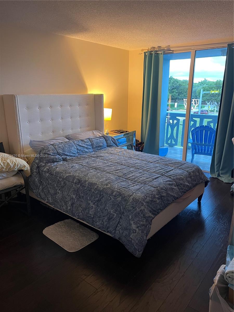 8233 Harding Avenue, Unit 305 Miami Beach, FL 33141 - Photo 25 of 46 a bedroom with a bed and wooden floor