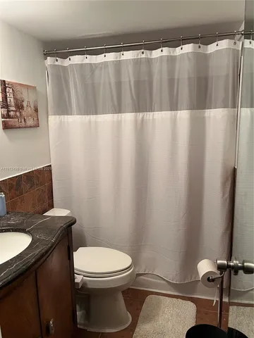 a bathroom with a sink a toilet a tub and shower